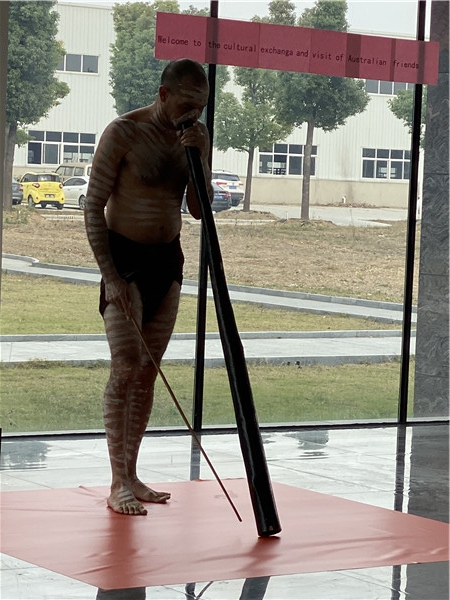 Australian clients perform Aboriginal instruments to employees